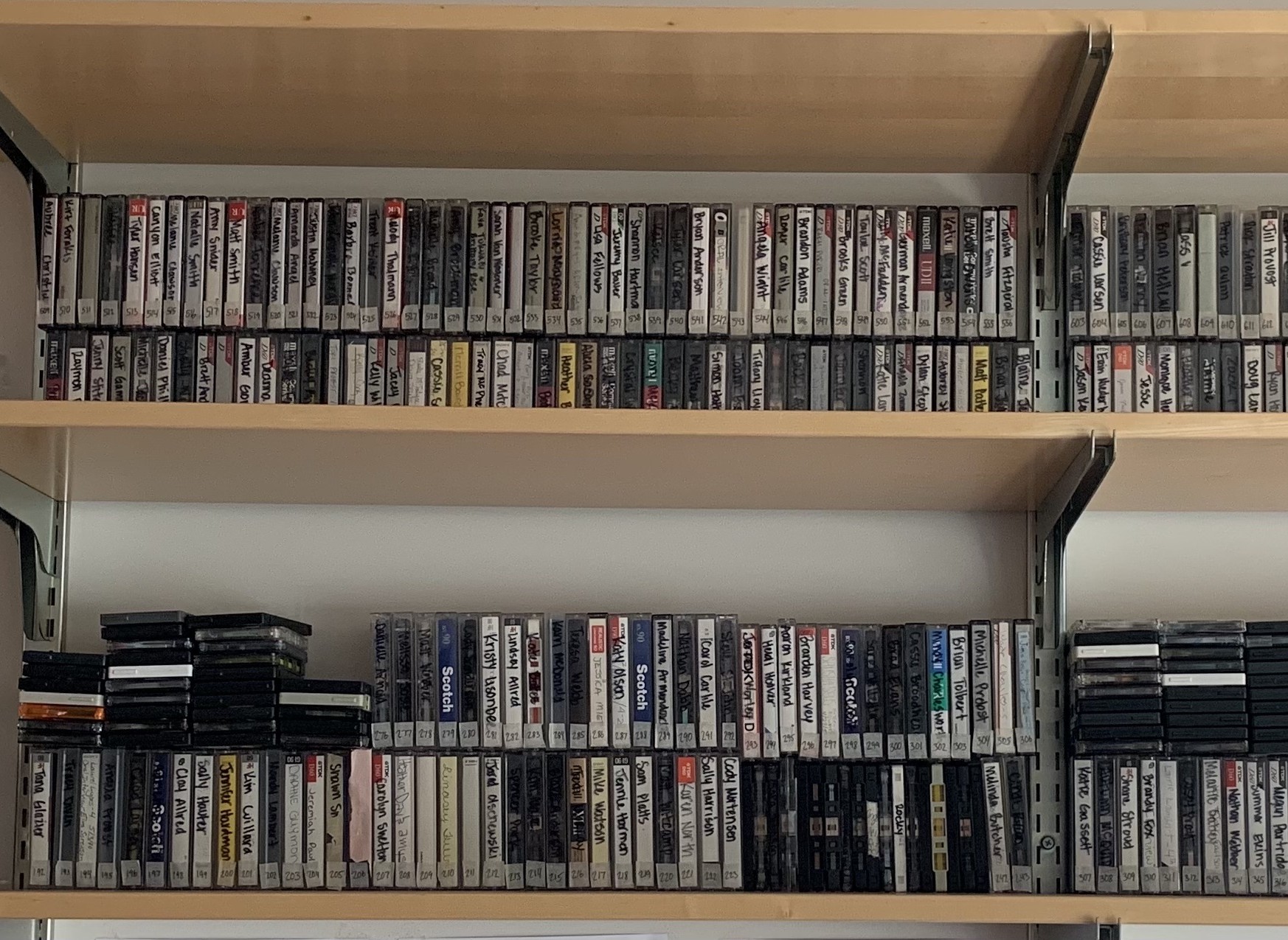 Shelf with hundreds of casette tapes on it