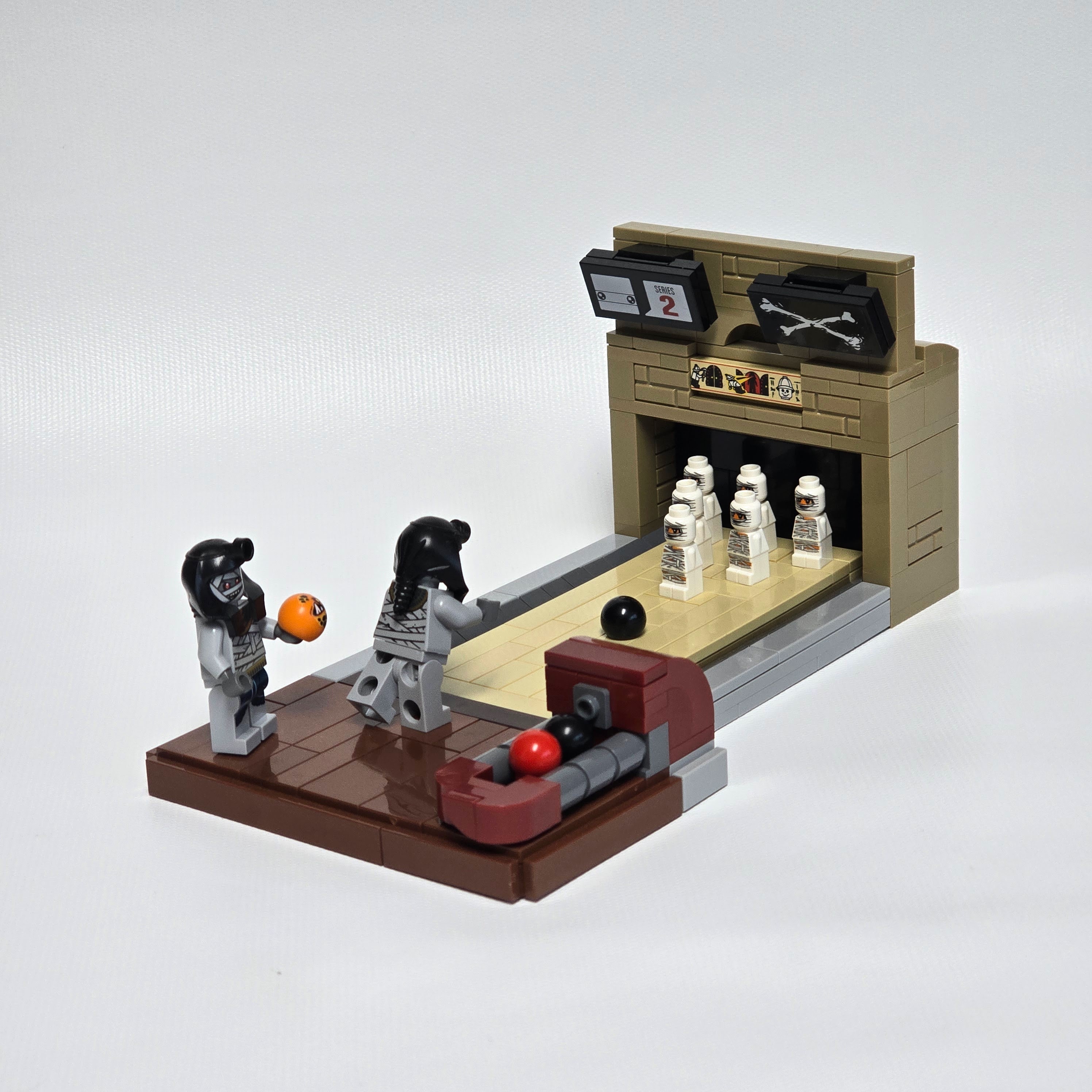Two Lego mummies bowling, The pins are smaller mummies, created by Alex Lyman